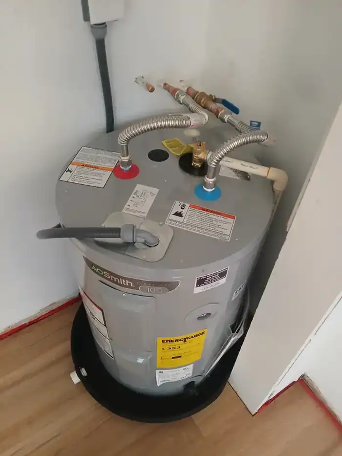 Electric water heater installation with new flex supply lines and drain pan